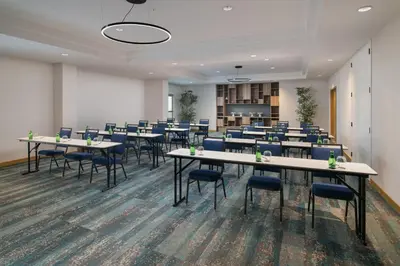 a conference room with tables and chairs in it at Courtyard by Marriott Santo Domingo in Santo Domingo