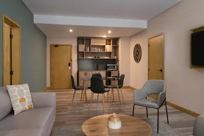 a living room with a couch and a table and chairs at Courtyard by Marriott Santo Domingo in Santo Domingo