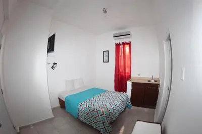a bedroom with a bed and a red curtain at Caribbean Hotel Santo Domingo in Santo Domingo