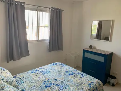 a bedroom with a bed and a blue dresser and a mirror at KSL Residence in Boca Chica