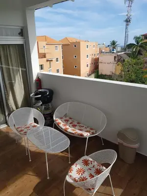 a balcony with three chairs and tables and a window at KSL Residence in Boca Chica