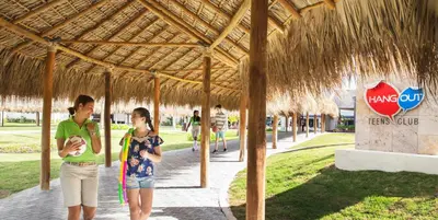 two people are standing under a straw roof at Royalton Bavaro, An Autograph Collection All-Inclusive Resort & Casino in Punta Cana