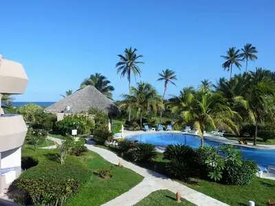 an aerial view of a resort with a swimming pool and palm trees at Luxury apartment with ocean view at the beach in Cabarete
