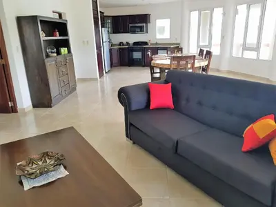a living room with a blue couch and a table at Luxury apartment with ocean view at the beach in Cabarete