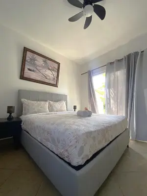 a bedroom with a bed with a ceiling fan and a window at Diamond Hotel Cabarete in Cabarete