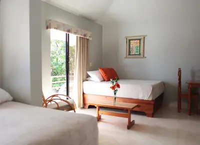 a bedroom with two beds and a table with flowers on it at Hotel Zapata in Boca Chica