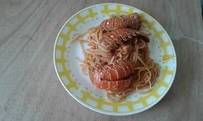 a plate of spaghetti with two cooked lobsters on it at Hotel Pedernales Italia Republica Dominicana in Pedernales