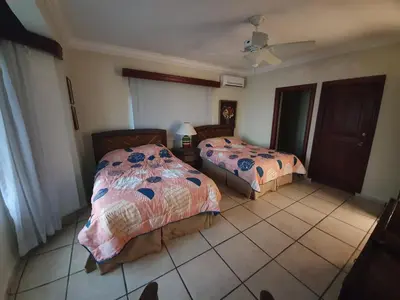 a bedroom with two beds and a tiled floor at Villa M-6 Metro Country Club in Juan Dolio