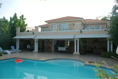 a large house with a swimming pool in front of it at Villa M-6 Metro Country Club in Juan Dolio