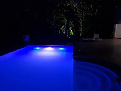 a swimming pool with blue lights in the dark at Villa M-6 Metro Country Club in Juan Dolio