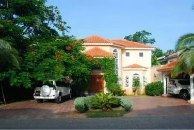 a house with a car parked in front of it at Villa M-6 Metro Country Club in Juan Dolio