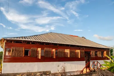 a house with a tin roof on top of it at Hostel La Ballena Backpacker in Las Galeras