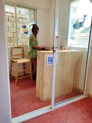 a woman standing at a counter in a room at Hostel La Ballena Backpacker in Las Galeras