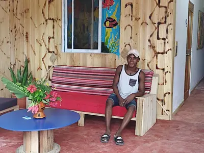 a man sitting on a bench in a room at Hostel La Ballena Backpacker in Las Galeras