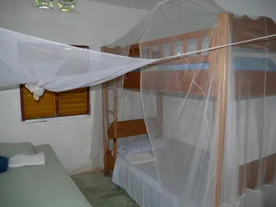 a bedroom with a bunk bed with a mosquito net at Ecotopía Park in El Hoyo del Cacao