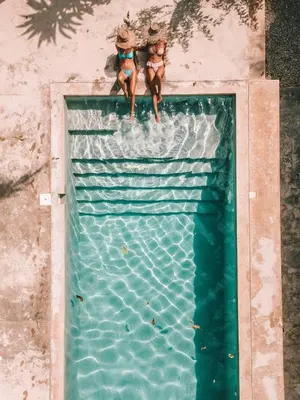 two people are standing on top of a swimming pool at Residencia El Balatà in Las Terrenas