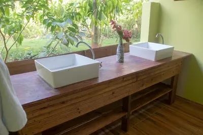 two white sinks on a wooden counter with a window at Aventura Rincon Ecolodge in Las Galeras