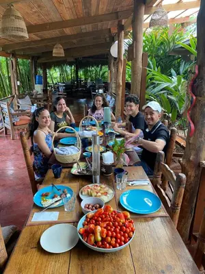 a group of people sitting around a table with food at Aventura Rincon Ecolodge in Las Galeras