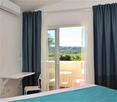 a bedroom with a bed and a window with a view at Tropical Casa Laguna in Cabarete