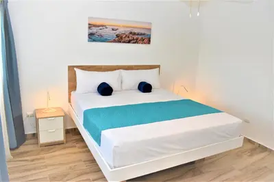 a bedroom with a white bed with blue sheets at Tropical Casa Laguna in Cabarete