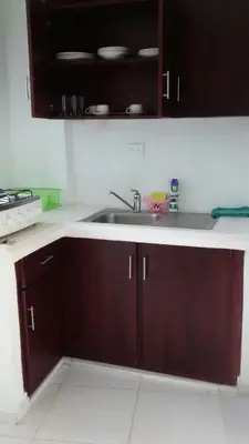 a kitchen with brown cabinets and a sink at Casa Vasquez in San Felipe de Puerto Plata