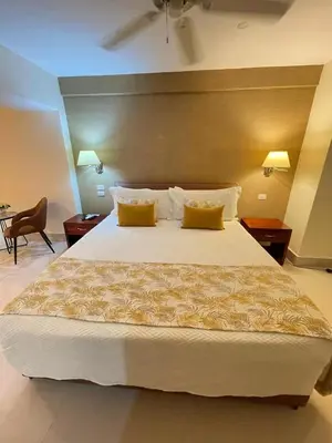 a bedroom with a large bed with two yellow pillows at Nilka Hotel Boutique in Santa Bárbara de Samaná