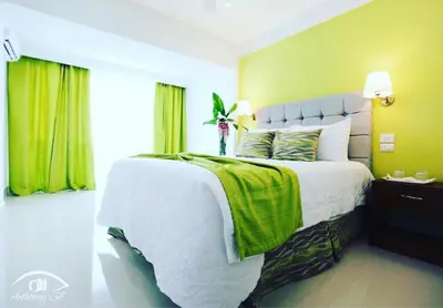 a bedroom with a large bed with a green wall at Nilka Hotel Boutique in Santa Bárbara de Samaná