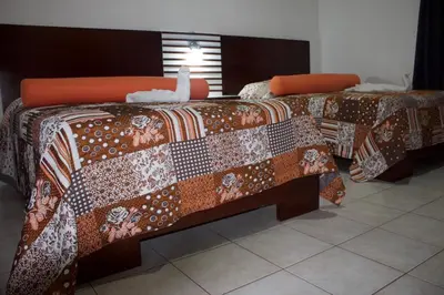 two beds in a room with a bird on them at Gran Hotel Marien in Sabaneta