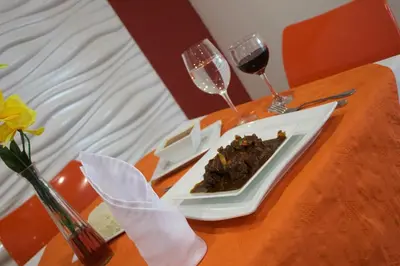 a plate of food on a table with two glasses of wine at Gran Hotel Marien in Sabaneta