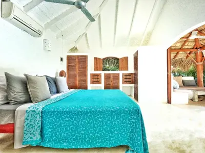 a bedroom with a bed with a blue blanket at Casa Picaflor B&B in Las Terrenas