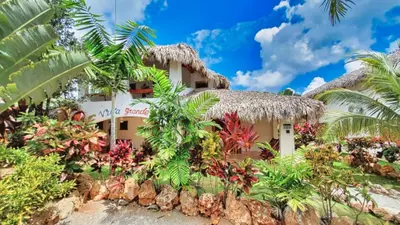 a resort building with a thatched roof at Paradiso del Caribe in Las Galeras