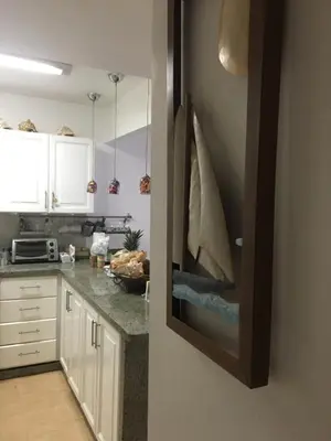 a kitchen with white cabinets and granite counter tops at Apartamento Juan Dolio in Juan Dolio