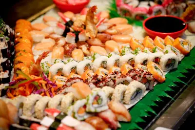 a display of sushi and other food on a table at Majestic Colonial Punta Cana - All Inclusive in Punta Cana