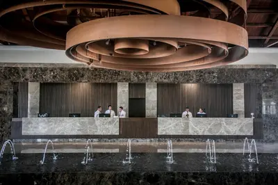 a lobby of a hotel with people standing at a counter at Majestic Colonial Punta Cana - All Inclusive in Punta Cana