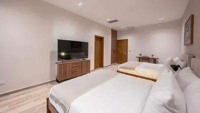 a hotel room with two beds and a flat screen tv at Mauad Hotel Boutique in Santo Domingo