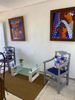 a room with two chairs and a glass table at Apartamentos Magallanes Romana in La Romana