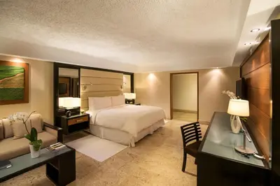 a hotel room with a bed and a desk at Casa de Campo Resort & Villas in La Romana