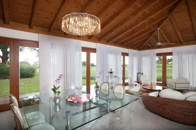 a living room with a glass table and chairs at Casa de Campo Resort & Villas in La Romana