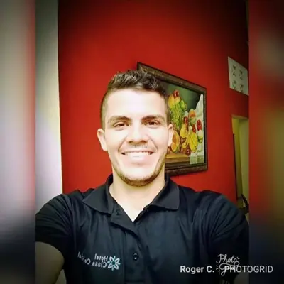 a man is smiling in a room with a red wall at Hotel Class Colonial in Santo Domingo