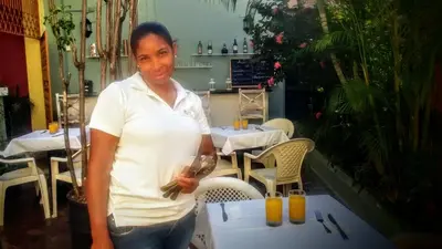 a woman standing in front of a table at Hotel Class Colonial in Santo Domingo