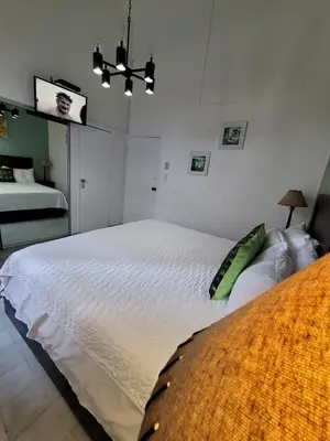 a bedroom with a large white bed in a room at Hotel Class Colonial in Santo Domingo
