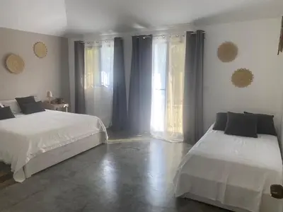 a bedroom with two beds and a large window at La Belle Créole in Las Galeras