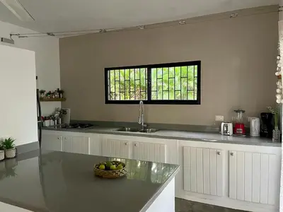 a kitchen with a sink and a bowl of fruit on a counter at La Belle Créole in Las Galeras
