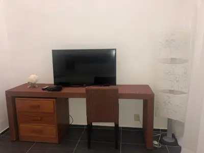 a wooden desk with a television on top of it at Spectacular Ocean View Top Floor 1-Bedroom Condo, Vista Mare, Samana DR in Santa Bárbara de Samaná