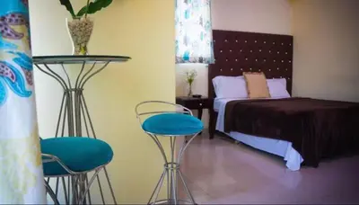 a bedroom with a bed and two blue bar stools at Hotel Luis V Santo Domingo in Santo Domingo