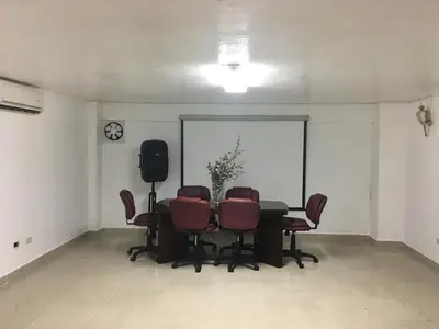 a conference room with a table and red chairs at Hotel Luis V Santo Domingo in Santo Domingo