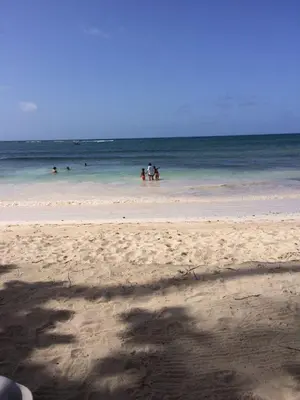 a group of people in the water at the beach at Residencial Green Paradise at Metro Country Club Juan Dolio - 2 Bedroom with Balcony in Juan Dolio