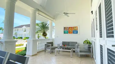 a porch with white columns and chairs and a table at Albachiara Hotel - Las Terrenas in Las Terrenas
