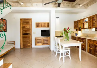 a kitchen with a table and a white table and chairs at Albachiara Hotel - Las Terrenas in Las Terrenas