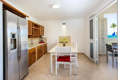 a kitchen with a white table and a refrigerator at Albachiara Hotel - Las Terrenas in Las Terrenas